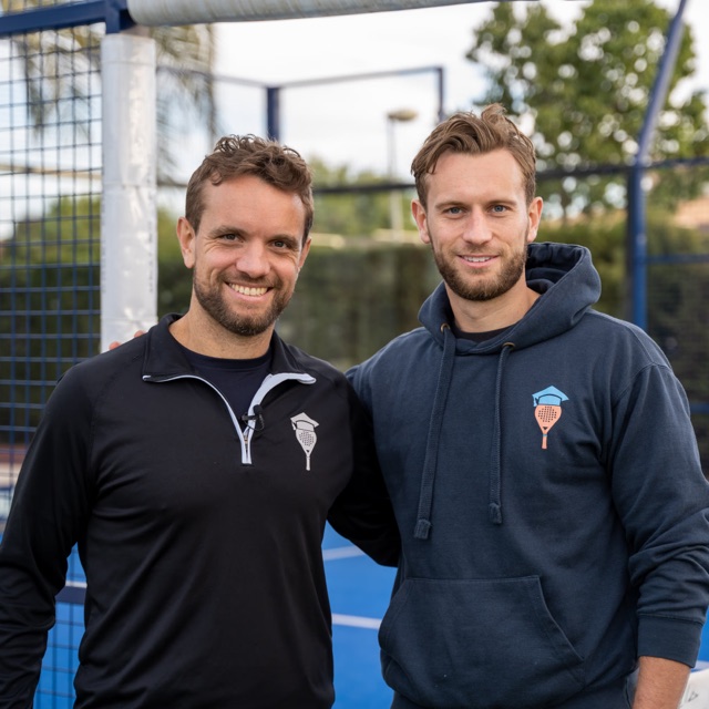 Two coaches from The Padel School smiling on an outdoor padel court