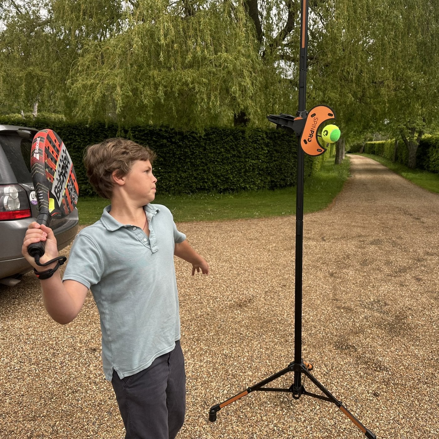 A junior player training with the SpinPro on the drive at home