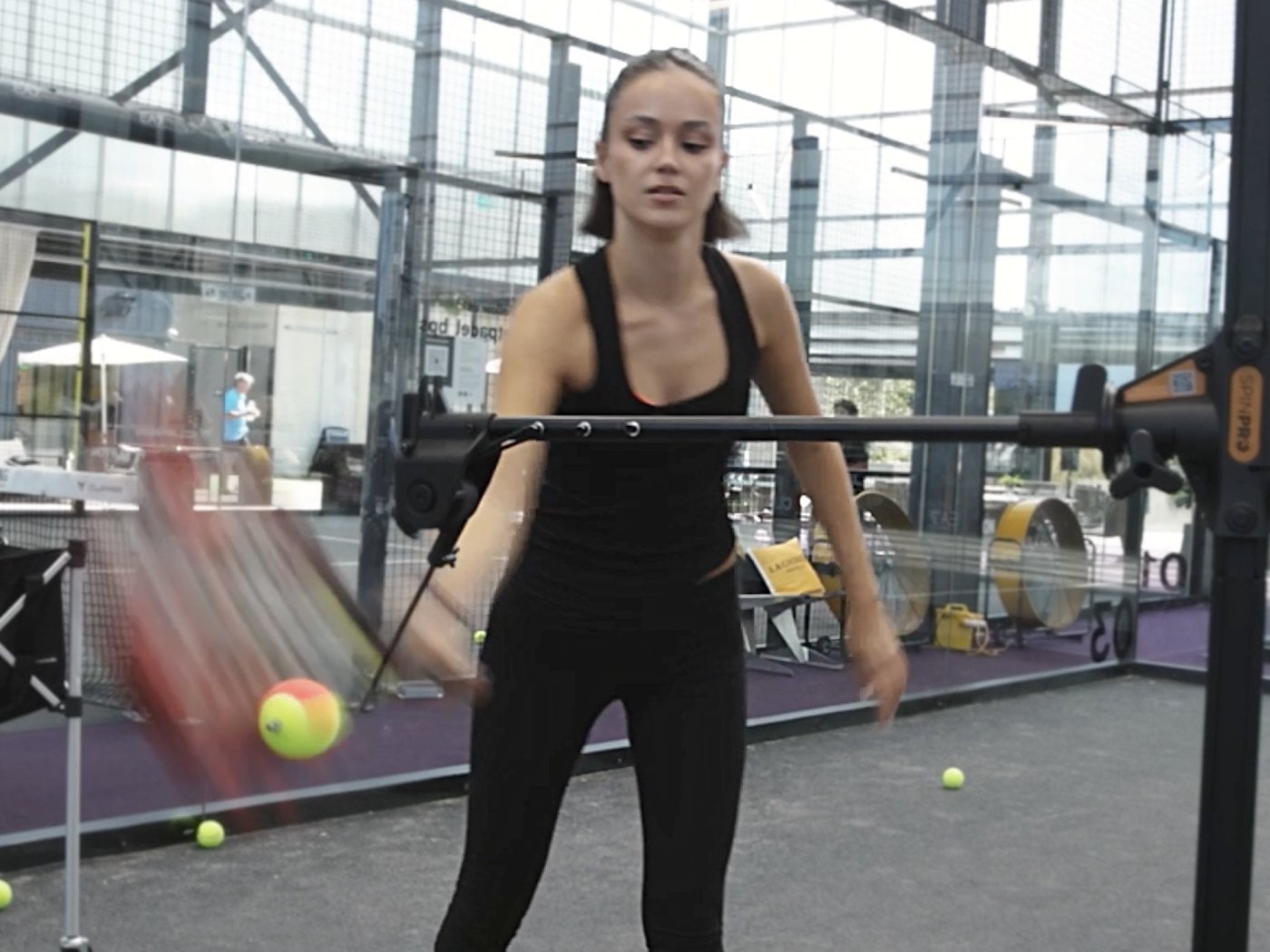 A padel player brushing up the back of the ball on the SpinPro