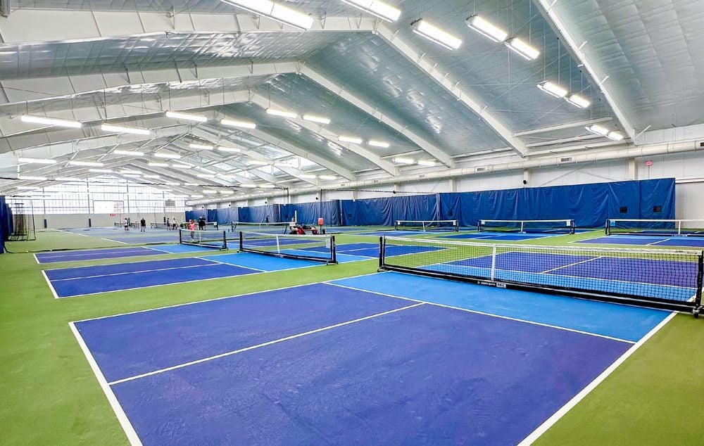 A large tennis club group photographed on court with SpinPro units
